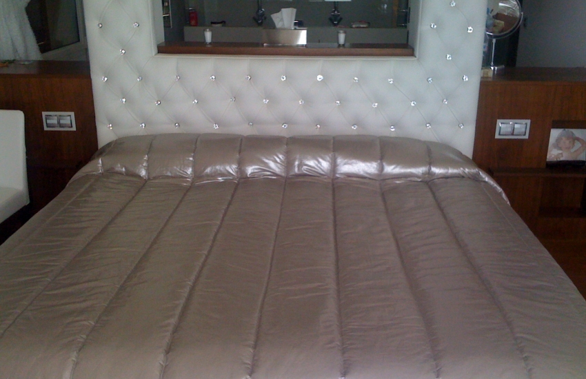 Tête de lit avec ouverture au milieu, recouverte en skaï et boutonnée de strass